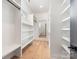 Bright walk-in closet with custom white shelving, hardwood floors, and ample storage at 3945 Plainview Rd, Charlotte, NC 28208