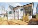 Exterior view of the home highlighting the deck area, yard, and neutral color palette at 3945 Plainview Rd, Charlotte, NC 28208