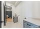 Well-lit laundry room with gray cabinets, quartz countertop, sink, and access to mudroom at 3945 Plainview Rd, Charlotte, NC 28208