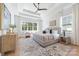 Serene main bedroom featuring a tray ceiling, large windows, and calming neutral color palette at 3945 Plainview Rd, Charlotte, NC 28208