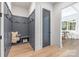 Mudroom with custom gray paneling, built-in bench, storage, and access to dining area at 3945 Plainview Rd, Charlotte, NC 28208