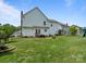 Spacious backyard with lush green grass and a patio with outdoor seating at 5535 Whispering Wind Ln, Indian Trail, NC 28079