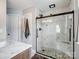 Bathroom featuring marble tile shower with seamless glass door and river rock flooring at 5535 Whispering Wind Ln, Indian Trail, NC 28079