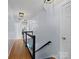 Upstairs hallway features hardwood flooring and glass-paneled railing with black trim at 5535 Whispering Wind Ln, Indian Trail, NC 28079