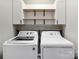 Well-organized laundry room with modern washer, dryer, and shelving at 5535 Whispering Wind Ln, Indian Trail, NC 28079