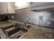 Kitchen features stainless steel sink and hexagonal backsplash at 1645 Arlyn Cir # J, Charlotte, NC 28213