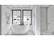 Luxurious bathroom featuring a soaking tub, elegant fixtures, and tiled shower at 4658 Sugar Plum Ln, Davidson, NC 28036