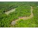 Aerial view of a wooded lot with pond and road at 1052 Ventosa Dr, Denver, NC 28037