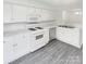 Modern kitchen featuring white cabinets, stainless steel appliances, and sleek gray flooring, great for cooking at 6003 Treetop Ct, Charlotte, NC 28212