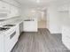 Bright kitchen with white cabinetry, modern appliances, sleek countertops, and stylish gray flooring at 6003 Treetop Ct, Charlotte, NC 28212