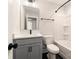 Bathroom featuring tub with gray tile, gray vanity, matte black fixtures, and black tile floor at 1409 Collier Walk Aly # Csw0104, Charlotte, NC 28205