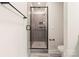 Bathroom featuring glass shower, gray tile, rain shower head, and matte black fixtures at 1409 Collier Walk Aly # Csw0104, Charlotte, NC 28205