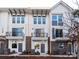 An exterior view shows the townhome with brick and white siding, a balcony and black railings at 1409 Collier Walk Aly # Csw0104, Charlotte, NC 28205