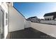 This outdoor deck has gray floor boards and white vertical plank railing with neighboring townhomes in the background at 1411 Collier Walk Aly # Csw0105, Charlotte, NC 28205