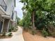 A well-maintained walkway showing townhouse exteriors with brick and gray accents, complemented by manicured landscaping at 1411 Collier Walk Aly # Csw0105, Charlotte, NC 28205