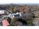 An aerial view showcasing modern townhomes surrounded by lush trees and city skyline in the background at 1413 Collier Walk Aly # Csw0106, Charlotte, NC 28205