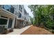 Modern townhome exterior featuring a sidewalk, partial brick facade, and balconies at 1413 Collier Walk Aly # Csw0106, Charlotte, NC 28205
