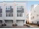 Modern townhomes with drive-under garages featuring neutral siding and complementary accents at 1413 Collier Walk Aly # Csw0106, Charlotte, NC 28205