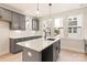 Kitchen features grey cabinetry, white countertops and eat in island with updated modern light fixtures at 1413 Collier Walk Aly # Csw0106, Charlotte, NC 28205