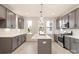Bright kitchen with grey cabinetry, stainless appliances, white countertops and eat in island at 1413 Collier Walk Aly # Csw0106, Charlotte, NC 28205