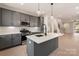 Modern kitchen has stainless appliances, island, and open access to the living room and staircase at 1413 Collier Walk Aly # Csw0106, Charlotte, NC 28205