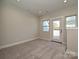 Neutral bedroom with a door leading to the exterior and three large windows at 1211 E 34Th St # Csw0313, Charlotte, NC 28205