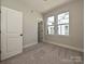 Cozy bedroom with neutral walls, carpet floors, and an open door to the hallway at 1211 E 34Th St # Csw0313, Charlotte, NC 28205