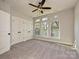 Bright bedroom featuring three windows, a ceiling fan, and a closet with double doors at 1211 E 34Th St # Csw0313, Charlotte, NC 28205