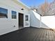 Open-air deck featuring wood-look flooring, exterior wall lighting, and a white-painted exterior, creating a cozy outdoor retreat at 1211 E 34Th St # Csw0313, Charlotte, NC 28205