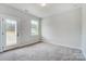Bright bedroom with a window and a glass door to outdoor views and carpeted floor at 2003 Cedar Falls Dr # 69, Waxhaw, NC 28173