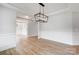 Open dining room with decorative trim, wood floors, modern chandelier, and access to other spaces at 2003 Cedar Falls Dr # 69, Waxhaw, NC 28173