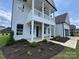 Welcoming front porch with classic columns, second story balcony, and beautifully landscaped garden, exuding charm at 2003 Cedar Falls Dr # 69, Waxhaw, NC 28173