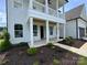 Inviting front porch with elegant columns, a second-story balcony, and professionally landscaped garden at 2003 Cedar Falls Dr # 69, Waxhaw, NC 28173