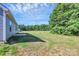 View of the house, large green backyard and tree-lined background at 6122 Lowder Rd, Salisbury, NC 28147