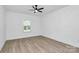 A bright bedroom featuring a window, light hardwood floors, and a modern ceiling fan at 6122 Lowder Rd, Salisbury, NC 28147