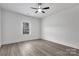 A clean, bright bedroom with neutral walls, ceiling fan, gray floors, and a window offering plenty of natural light at 6122 Lowder Rd, Salisbury, NC 28147