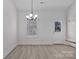 Dining area with a modern chandelier, large window, and access to the back door and adjacent kitchen at 6122 Lowder Rd, Salisbury, NC 28147