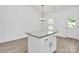 Kitchen island features granite countertops, white cabinets, bar seating, and electrical outlets at 6122 Lowder Rd, Salisbury, NC 28147