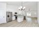 Well-lit kitchen with stainless steel appliances, granite countertops, white cabinetry, a kitchen island and hardwood flooring at 6122 Lowder Rd, Salisbury, NC 28147