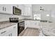 Modern kitchen with stainless steel appliances, granite countertops, white cabinetry, and hardwood flooring at 6122 Lowder Rd, Salisbury, NC 28147