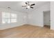 Bright living room with wood-look floors, a ceiling fan, and natural light streaming through the windows at 6122 Lowder Rd, Salisbury, NC 28147