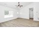 Bright open-concept living area showcasing hardwood floors, white walls, large window, and entry to kitchen at 6122 Lowder Rd, Salisbury, NC 28147