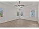 This bedroom features light wood-look floors, a ceiling fan, and bright natural light from three windows at 6154 Lowder Rd, Salisbury, NC 28147