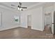This bedroom features light wood-look floors, a ceiling fan, and an ensuite bath and hallway access at 6154 Lowder Rd, Salisbury, NC 28147