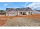 New construction featuring a large attached garage and covered entryway, surrounded by a raw landscape at 6154 Lowder Rd, Salisbury, NC 28147