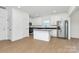 Well-lit kitchen with stainless steel appliances, large island, and sleek, wood-look flooring at 6154 Lowder Rd, Salisbury, NC 28147