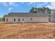 New construction featuring a simple rear exterior with minimal landscaping and a view of the tree line at 6154 Lowder Rd, Salisbury, NC 28147