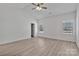 Light-filled primary bedroom with neutral walls, light wood floors, two windows, and ceiling fan at 6160 Lowder Rd, Salisbury, NC 28147