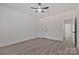 Bright bedroom with wood-look floors, ceiling fan, and doorway to another room at 6160 Lowder Rd, Salisbury, NC 28147