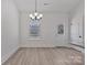 Bright dining area with stylish chandelier, wood-look floors, and a modern door at 6160 Lowder Rd, Salisbury, NC 28147